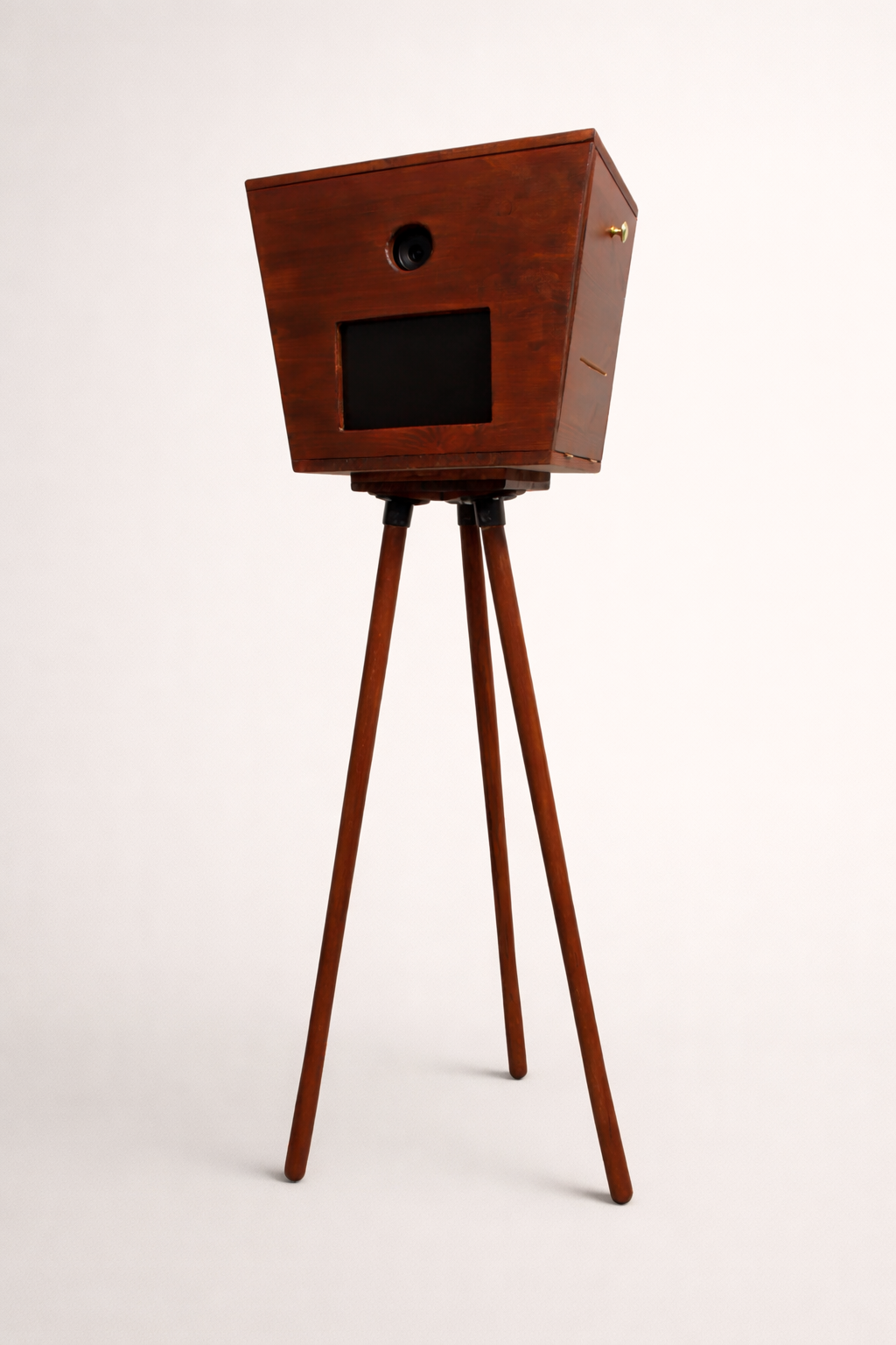 De Luxo Photobooth van Luxo is een cabine in vintage stijl met een houten rechthoekige doos, drie driepoten, een kleine ronde lens en een rechthoekig scherm - ideaal voor bruiloften of evenementen. Weergegeven tegen een effen witte achtergrond.